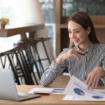 Charming asian businesswoman sitting working on laptop in office.